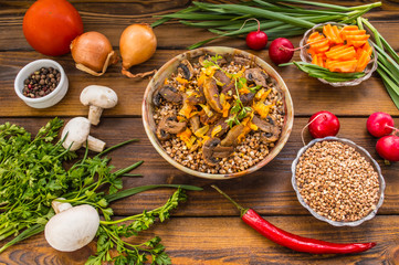 Buckwheat porridge with meat and mushrooms on wooden rustic background. Top view