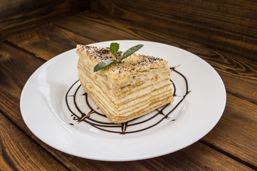 Napoleon cake with mint leaves and chocolate on an old table. Top view