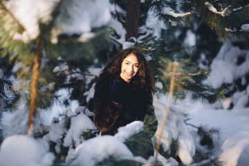 Beautiful young girl in a snowy forest