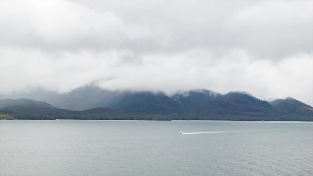 Majestic Strait of Magellan with Epic Mountains in Background and Small Boat on Foreground Water