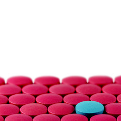 Obraz na płótnie Canvas Blue pill between red pills on white background