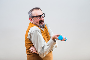 Nerdy businessman is trying to exercise with weights but they are too heavy for him.
