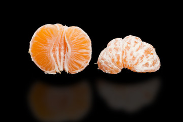 Juicy mandarin, two Half peeled mandarin on pure black.
