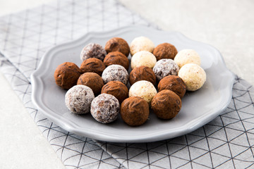 Assorted chocolate truffles with cocoa powder, coconut and chopp