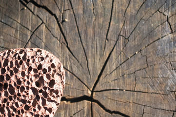 pumice stone with a cord on old wooden background
