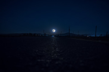full moonlight  night  over the asphalt road and mountains