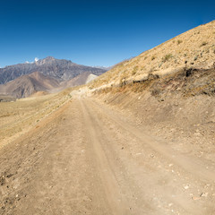Dirt road through arid mountain wastelands.