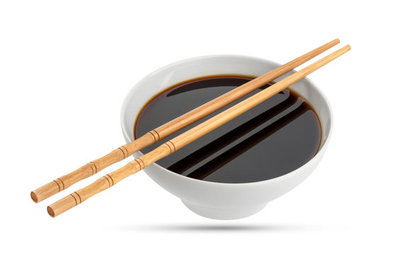 Soy sauce and chopsticks isolated on white