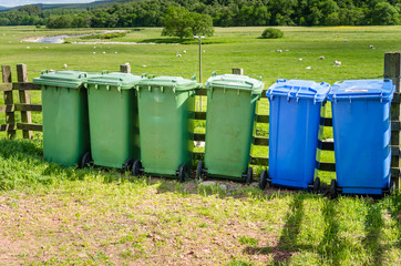 Row of Colourful Recycling Bins in a Rural Landscape