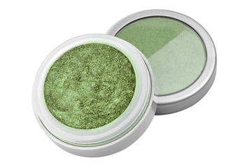 Green color eyeshadow powder with glitter particles, in round grey open container sitting on its lid, beauty product isolated on white background