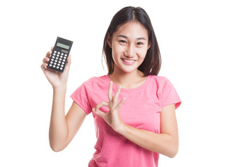 Asian business woman show OK with calculator.