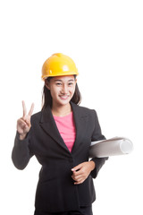 Asian engineer woman with blueprints show victory sign.