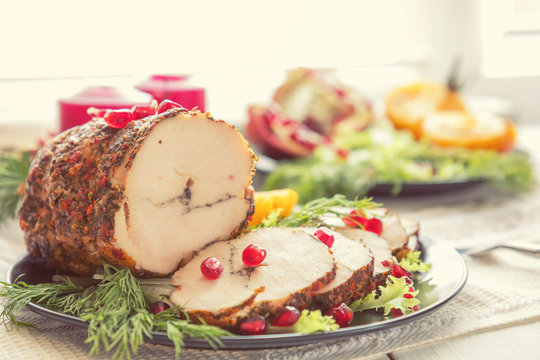 Christmas holiday dinner. Stuffed chicken breast with herbs, tomatoes, pomegranate and spices against holiday  background. Coloring and processing photo.
