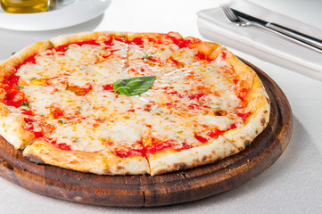 Selective focus traditional stone-baked pizza Margarita on served restaurant table