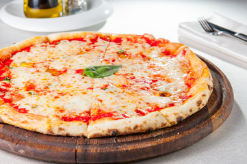 Selective focus traditional stone-baked pizza Margarita on served restaurant table