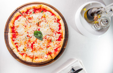 Selective focus traditional stone-baked pizza Margarita on served restaurant table. Top view