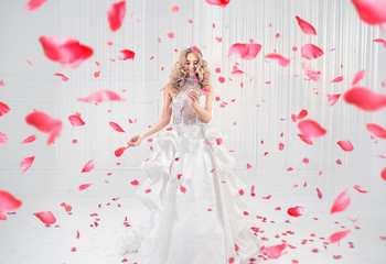 Pretty, elegant blonde dancing among rose petals