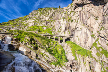 Railway bridge Teufelsbrucke over Reuss river in St. Gotthard mountain range of Swiss Alps near...