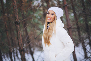 Smiling, happy young girl walking in winter forest