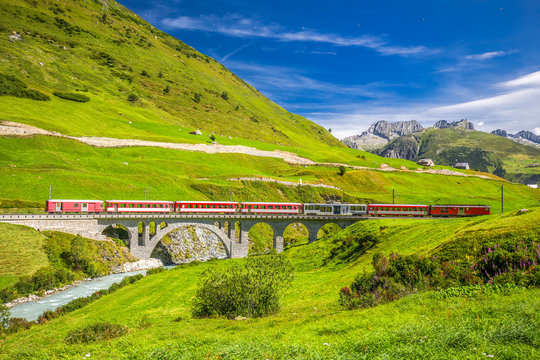 The Matterhorn - Gotthard - Bahn train on the viaduct bridge near Andermatt in Swiss Alps