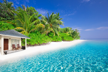 Fototapeta na wymiar Luxurious over-water bungalows in beautiful lagoon on tropical island