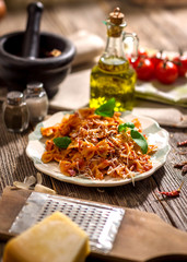 Pasta with tomato sauce on wooden background