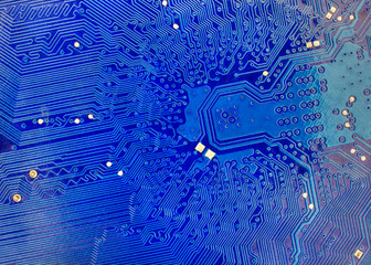 Technological background with blue computer motherboard closeup