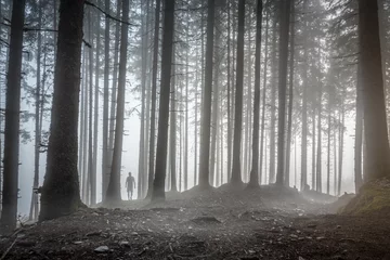 Gordijnen Man wandelen door een mistig bos © mRGB