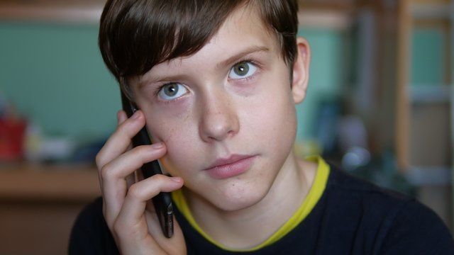 Teen boy talking on the phone indoor smartphone