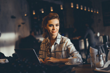 young pretty brunette woman eat chocolate in cafe, using smartphone and laptop touch screen display, sweet food, tasty breakfast, close up portrait, hipster girl, fanny, drink coffee