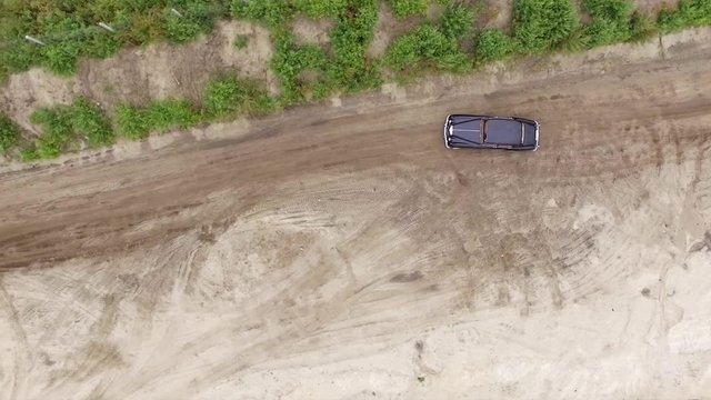 Aerial footage. Vintage car driving on a sandy shore. Vertical view with rotate.