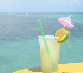 Caipirinha drink in boat support with a blue sea background on a beautiful sunny day.
