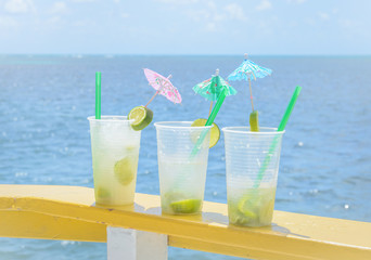 Caipirinha drink in boat support with a blue sea background on a beautiful sunny day.