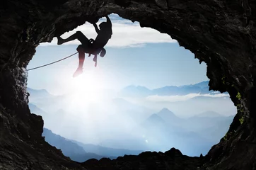 Abwaschbare Fototapete Bergsteigen Bergsteiger im Hochgebirge an einem Höhlenausgang