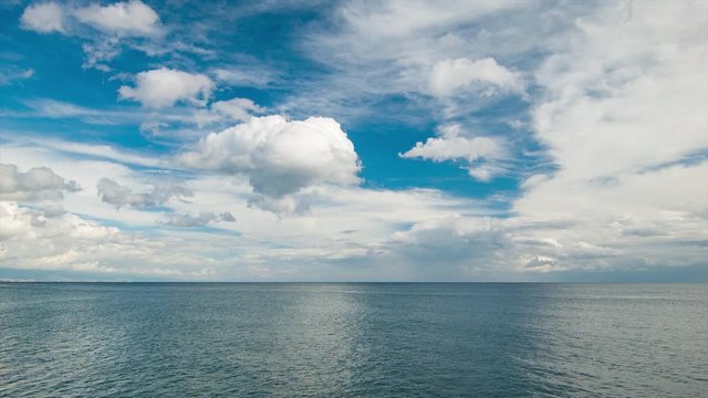 Wide Mediterranean Seascape in Southern Spain with Dramatic White Clouds in a Blue Sky Over Calm Ocean Water near the Spanish Resort Destination of Estepona