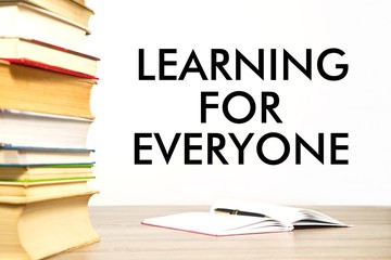 Stack of books on table with message