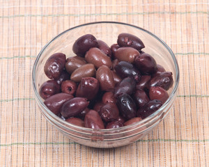 Jumbo pitted kalamata olives in bowl on bamboo placemat