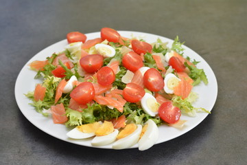 Salmon salad with lettuce, eggs and tomatoes.