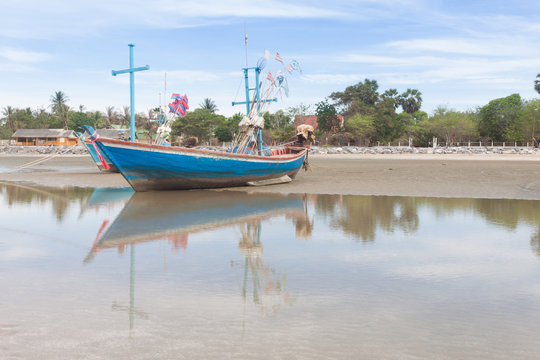 Wooden fishing boat on the  low tide beach.