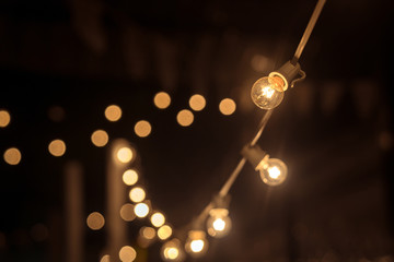 Garland of lights. Vintage style. Background of light bulbs in a field in the rest blurring. Party...