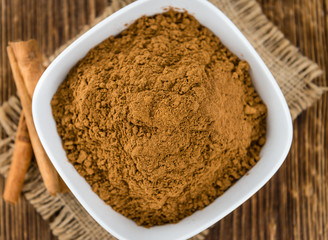 Portion of Cinnamon Powder on wooden background (selective focus