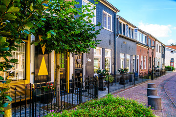 Quiet street in the historic Dutch Fishing Village of Bunschoten-Spakenburg with Renovated Row Houses on a Sunny Summer day