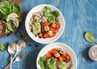 Quinoa with pumpkin, spinach and avocado. Healthy quinoa bowl. On a blue background, top view. Flat lay