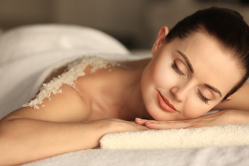 Obraz na płótnie Canvas Young woman lying on massage desk with scrub on back