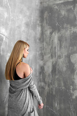 Pretty young blonde woman against grunge background