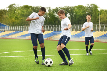 Boys playing football at stadium