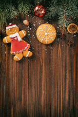 Composition of tasty gingerbread cookies and Christmas decor on wooden background