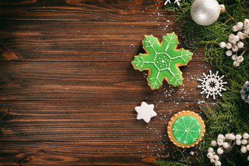 Composition of tasty gingerbread cookies and Christmas decor on wooden background