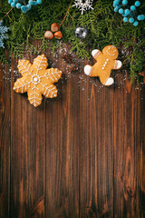 Composition of tasty gingerbread cookies and Christmas decor on wooden background
