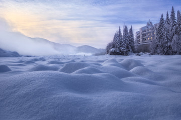 Castle on the River/The hotel, which stands on the bank of a frozen river. In its windows reflect...